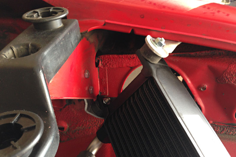 Here is another view of the upper oil cooler mount. The outer mount is attached to the fender with rivets and the inner mount is attached to a bumper standoff with a pair of M5 bolts.