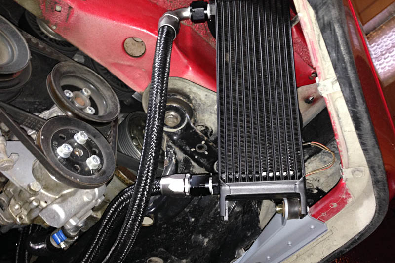 This shows the lower mount in place. The aluminum mount is riveted to a steel strip that bolts through the spoiler lip and into a steel superstructure that supports the valance below the bumper cap.