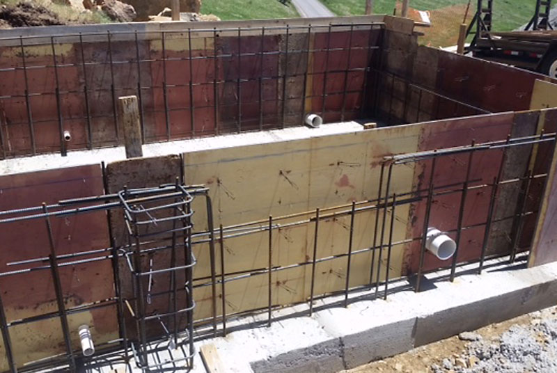 This is a view just inside the garage looking at the east carport. Pass-throughs for sewer and propane are visible near the bottom of the foundation forms in a total of four places.