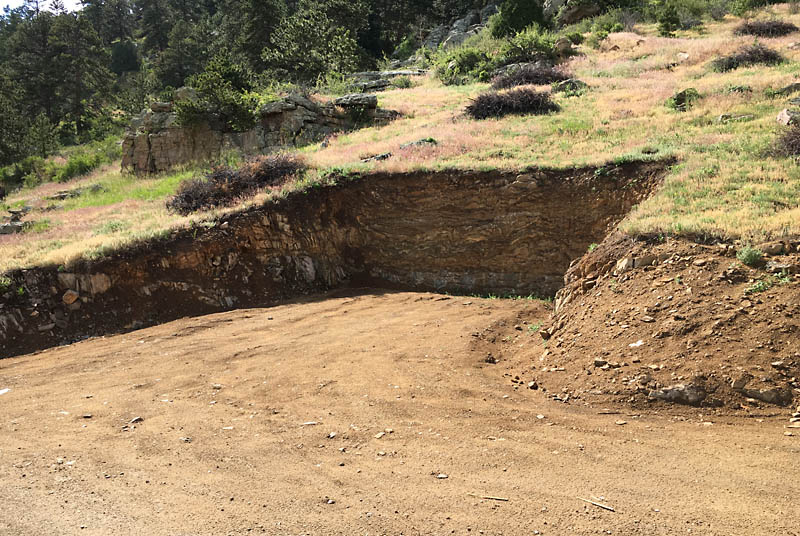 About 100 feet from the house is a hammerhead turn around cut into the uphill side of the driveway. This feature allows fire trucks to turn around and is required by code. It's also a handy place to store things during construction.