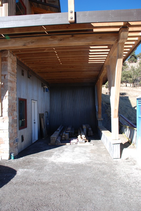 Here is the east carport. We're temporarily storing extra building materials here. The door will get painted dark brown in the near future.