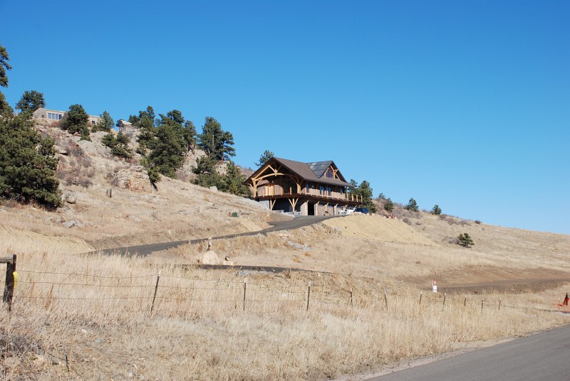 This view of the house is from the county road. The recycled asphalt driveway surface is just visible.