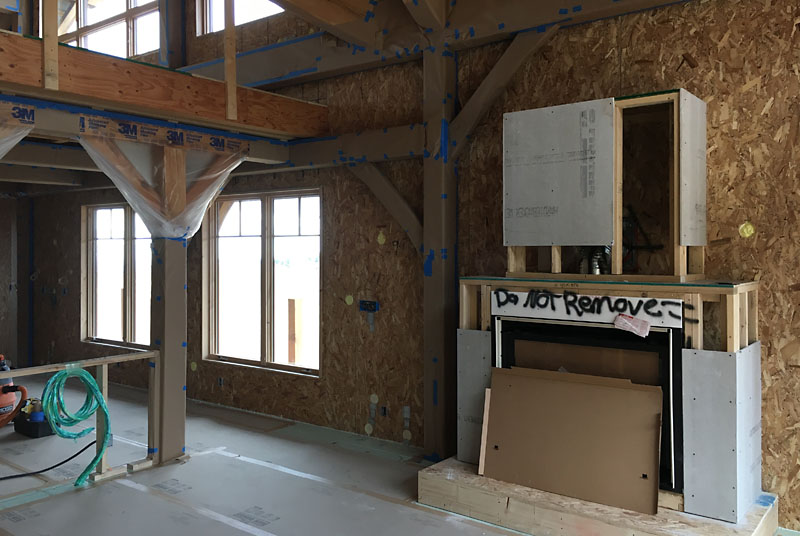 Prior to installing drywall, all the timbers adjacent to drywall have to be protected. Here you can see plastic, paper and blue tape on some of the timbers in the living room.