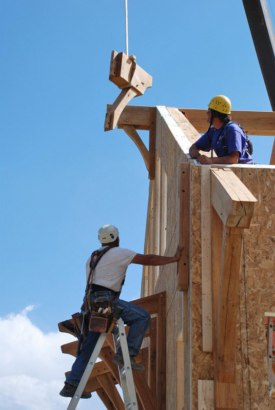 Most of the beam and rafter extensions are too heavy to place by hand. This is a beam extension at the northeast corner being flown in by the crane.