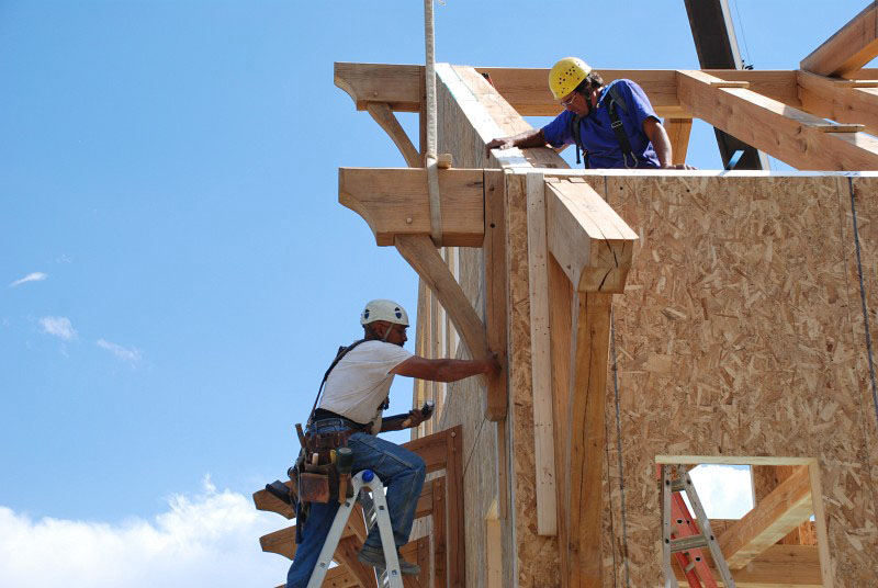 The crane operator responds to hand signals from another crew member (not visible here) and is able to place the beam extension right into the receiving plate.