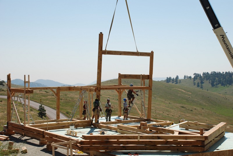 After the posts are fitted into the floor, the mortise and tenon joints that secure the beams to bent 5 are secured.