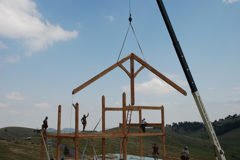 Matt (left hand raised) is giving the crane operator hand signals to fly the rafters into place.