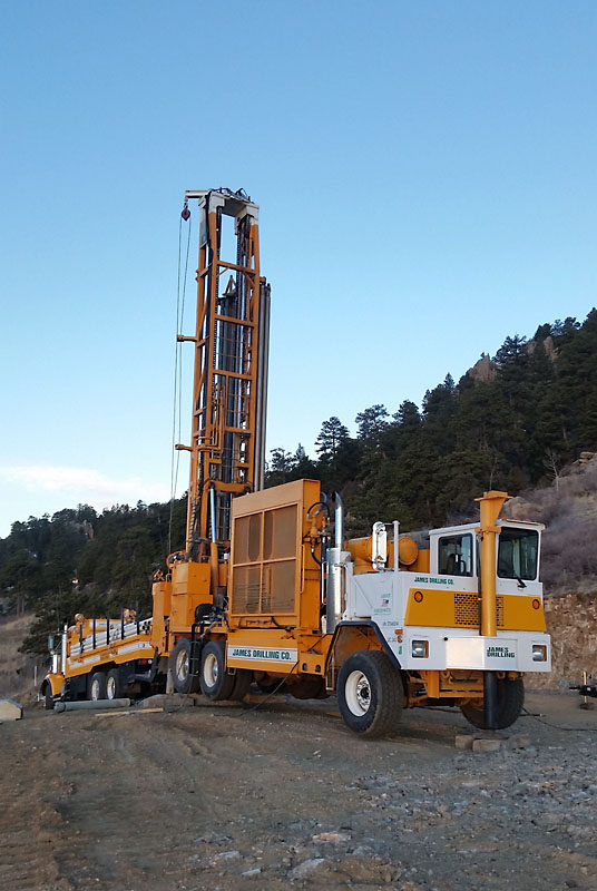 The well drilling rig is set up in front of the garage.