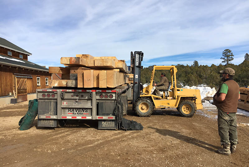 Darby is using the forklift to unload 5,000 pound bundles of timbers.