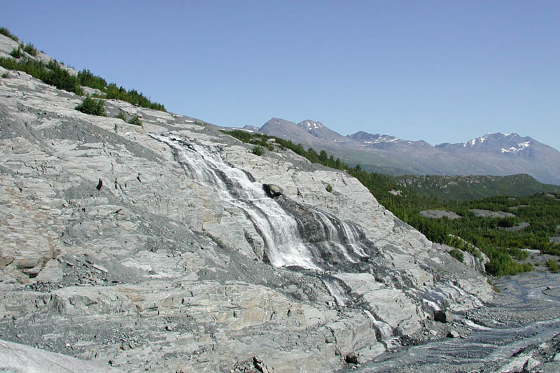 Water streams down the bare rock from the glacier above. In many places, this rock is polished too smooth to climb without ropes.